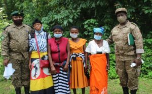 Mr. Balyasima Godfrey (Incharge warden of Semliki Np) and Ms. Norah Bumbi the community liaison officer of UWA take a photo with the Batwa women defenders after the advocacy meeting.