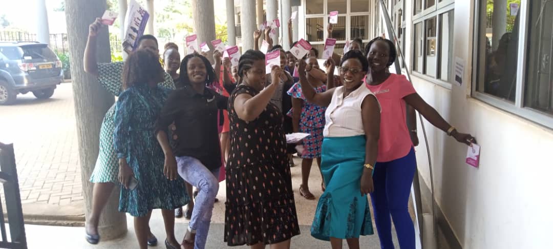 A group photo of WHRDS raising the online GBV handbook guide for WHRDS